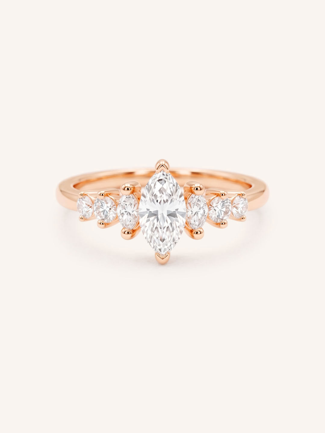 Rose Gold marquise diamond ring with graduated marquise and round side stones on white background