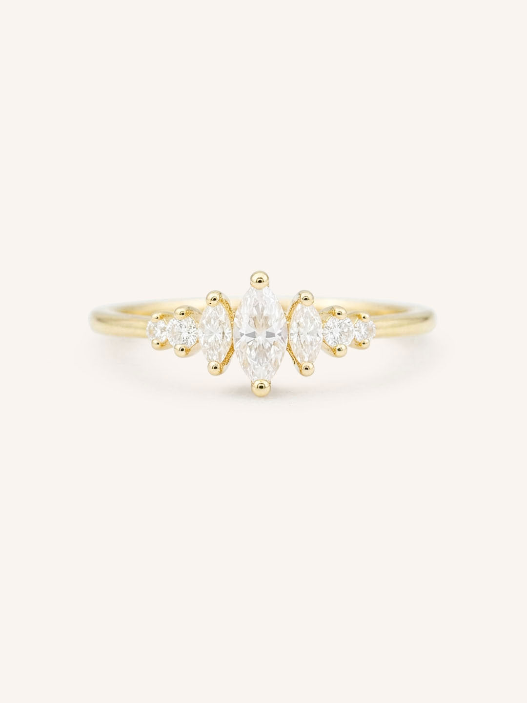 Gold ring with three Marquise diamonds and four round diamonds on a white background
