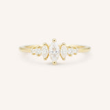 Gold ring with three Marquise diamonds and four round diamonds on a white background