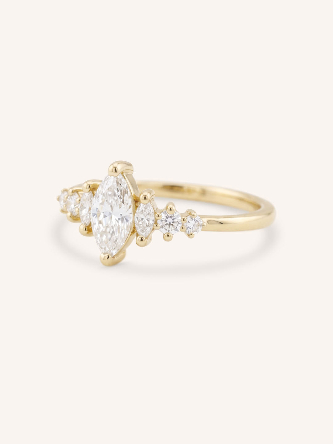 Yellow Gold marquise diamond ring with graduated side stones, side view, on white background