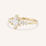 Yellow Gold marquise diamond ring with graduated side stones, side view, on white background