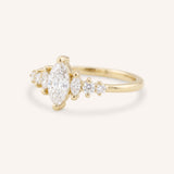 Yellow Gold marquise diamond ring with graduated side stones, side view, on white background