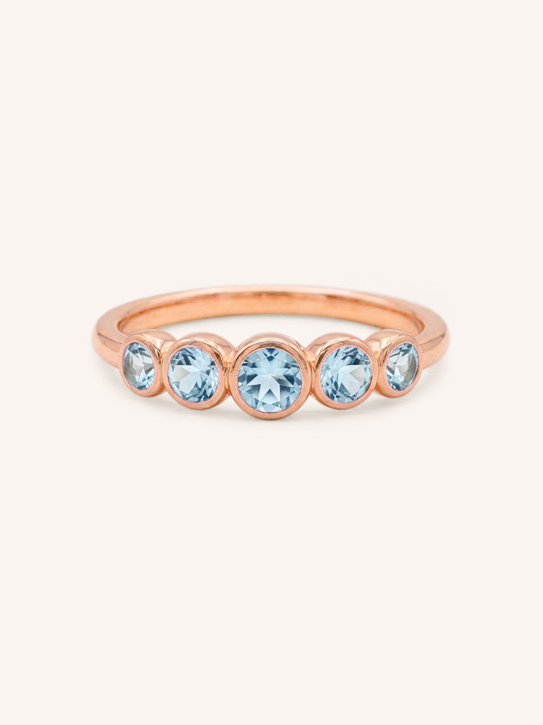 Rose gold Bonneau five stone aquamarine bezel ring front view on white background