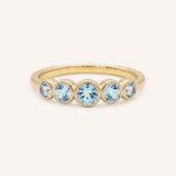 Yellow gold Bonneau five stone aquamarine bezel ring front view on white background
