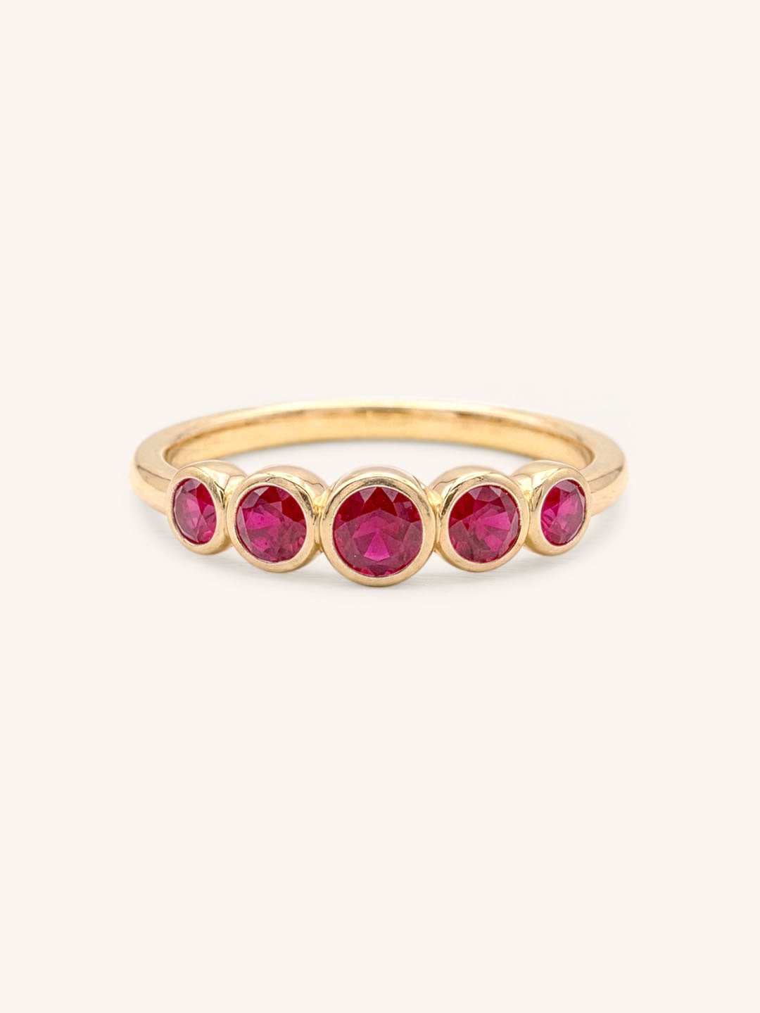Yellow gold Bonneau five stone ruby bezel ring front view on white background