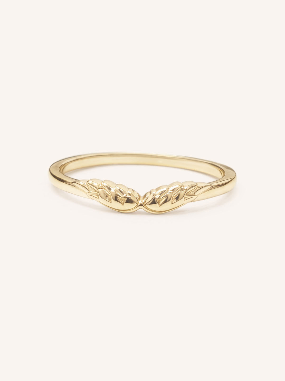Yellow gold stackable ring with carved angel wings design, front view, on white background