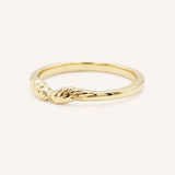 Yellow gold stackable ring with carved angel wings design, side view, on white background