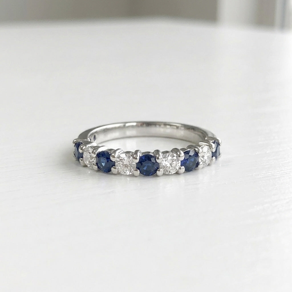 Blue sapphire alternating diamond band ring on white background