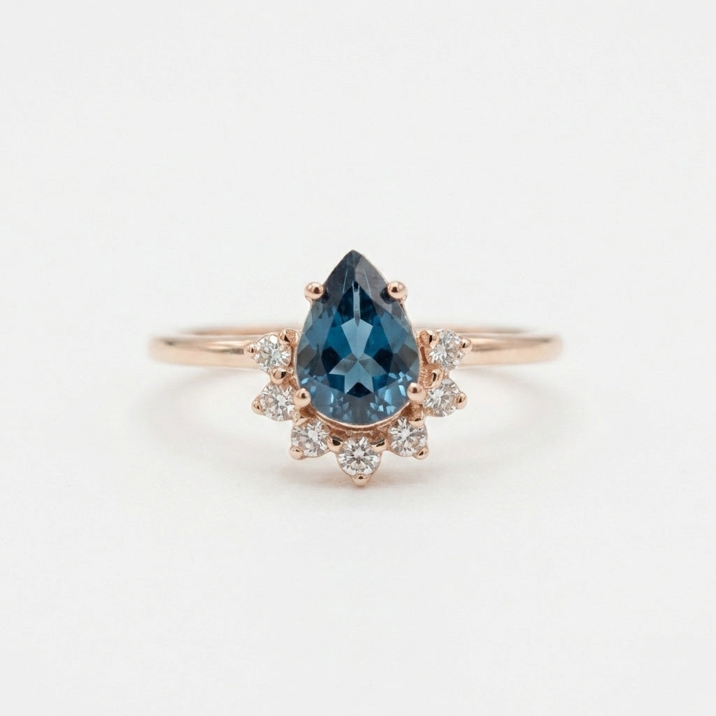 Pear shaped diamond crown halo ring on white background