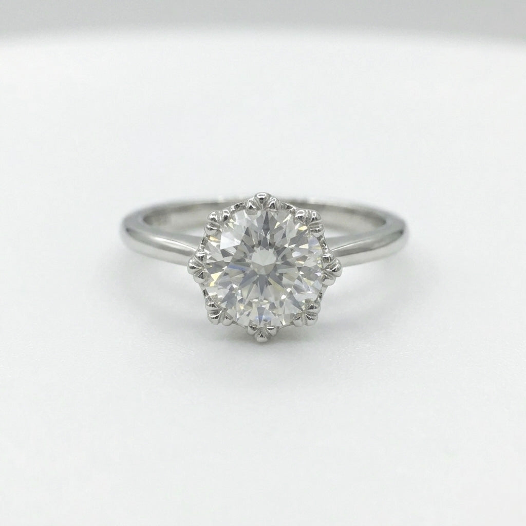 Round diamond crown solitaire ring on white background