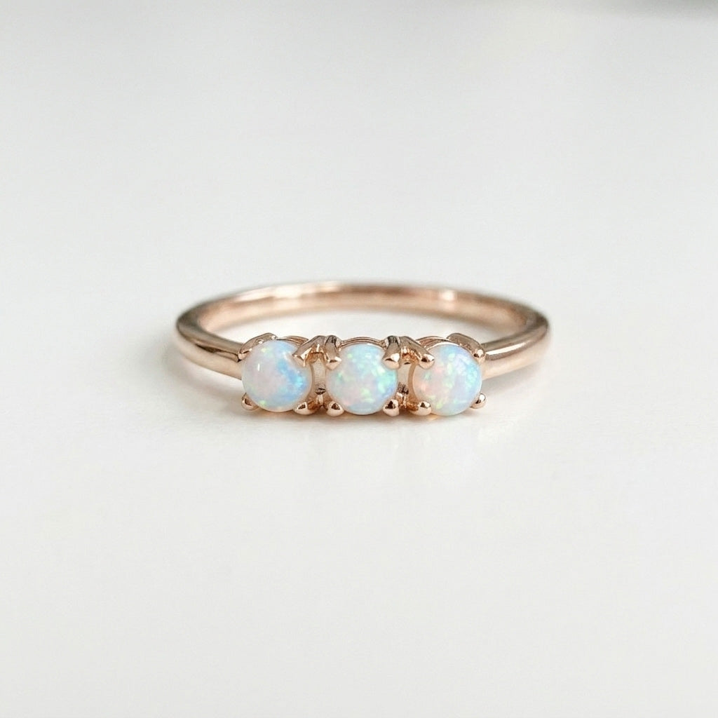 Triple opal rose gold ring on white background
