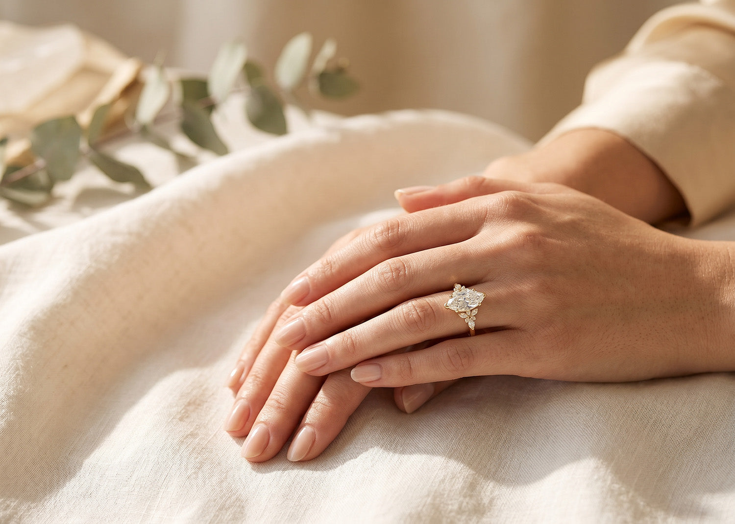 Close-up of a hand wearing a diamond ring on a soft surface with a blurred background